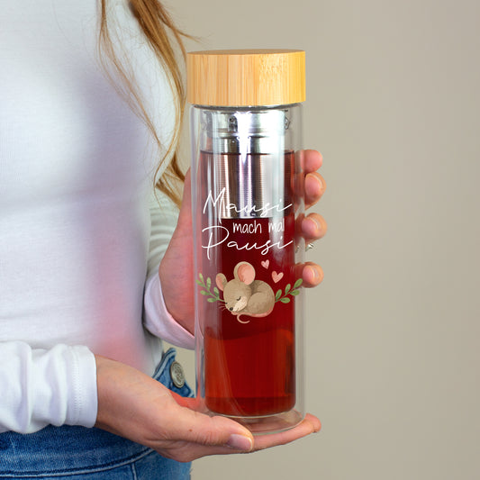 Frau hält doppelwandige Glasflasche mit rotem Tee, Edelstahl-Teesieb, Bambusdeckel und Maus-Aufdruck Mausi mach mal Pausi
