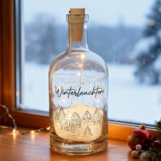 Leuchtende Winter-Karaffe mit LED-Lichterkette und Wunschtext „Winterleuchten“ auf Fensterbank im Schneeambiente.