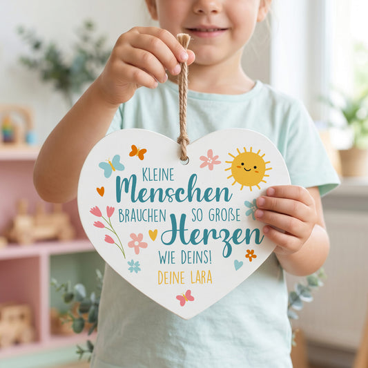 Kind hält personalisiertes Holzherz mit buntem Erzieherin Spruch und Wunschtext Deine Lara