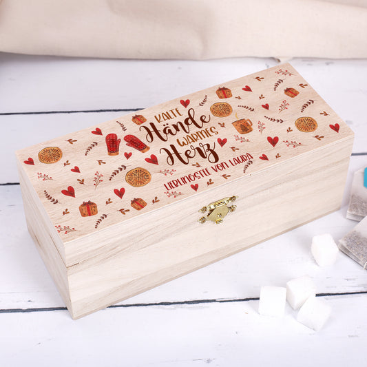 Teebox aus Holz mit Gravur „Kalte Hände, warmes Herz“ und Name Laura – Deckel mit roten Herzen, Plätzchen und Handschuh-Motiven auf hellem Holz, goldener Verschluss sichtbar.