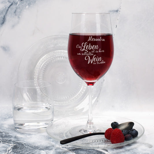 Personalisiertes Leonardo-Weinglas mit Gravur-Spruch „Das Leben ist zu kurz, um schlechten Wein zu trinken“, befüllt mit Rotwein und dekoriert mit Beeren