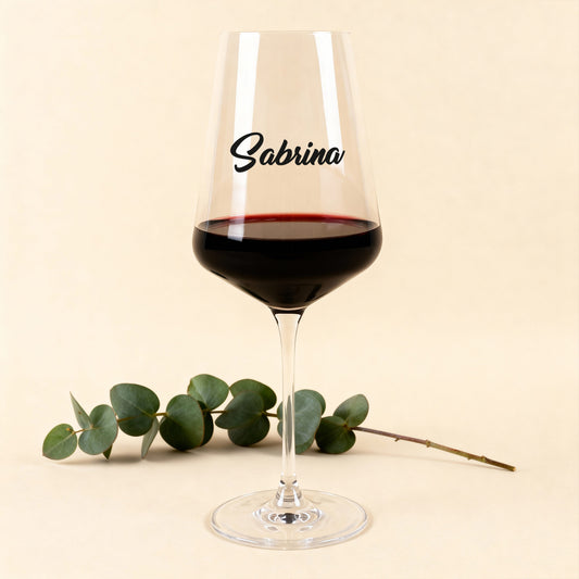 Leonardo Weinglas Puccini mit schwarzem Namensdruck, gefüllt mit Rotwein, vor hellem Hintergrund