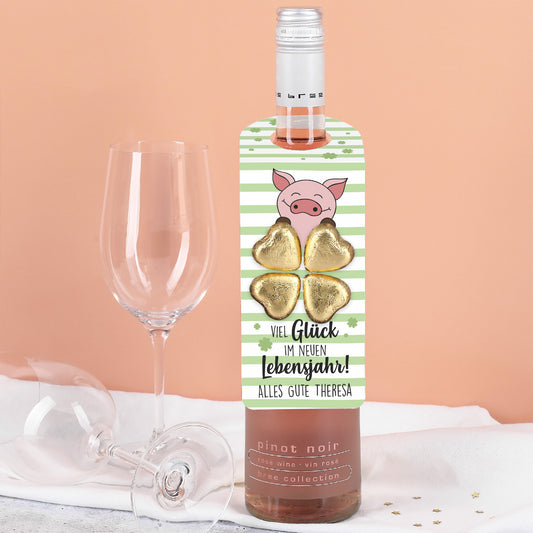 Vier goldene Lindt Schokoladenherzen, in Form eines Kleeblatts auf dem Flaschenanhänger arrangiert.