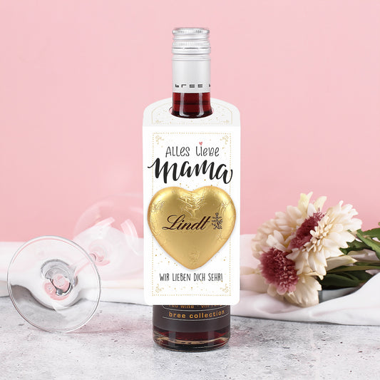 Kleiner Flaschenanhänger in Weiß mit goldenen Akzenten, goldfarbenem Lindt Schokoladenherz und dem Schriftzug „Alles Liebe Mama“, an einer Flasche befestigt.