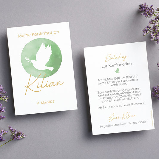Set aus zwei Einladungskarten zur Konfirmation im eleganten Design mit einem grünen Aquarell-Kreis und einer weißen Taube als Symbol des Glaubens. Die Vorderseite zeigt den Namen "Kilian" in goldener Schreibschrift sowie das Datum der Konfirmation. Die Rückseite enthält den Einladungstext in einer stilvollen Kombination aus gedruckter und handschriftlicher Typografie. Beide Karten liegen auf einem grauen Hintergrund, umgeben von zarten lila Blüten, die eine feierliche Atmosphäre vermitteln.
