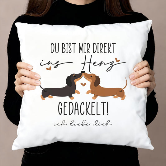 Kissen mit Dackel-Motiv „Du bist mir direkt ins Herz gedackelt!“ und Wunschtext, Dekoaufnahme mit Person