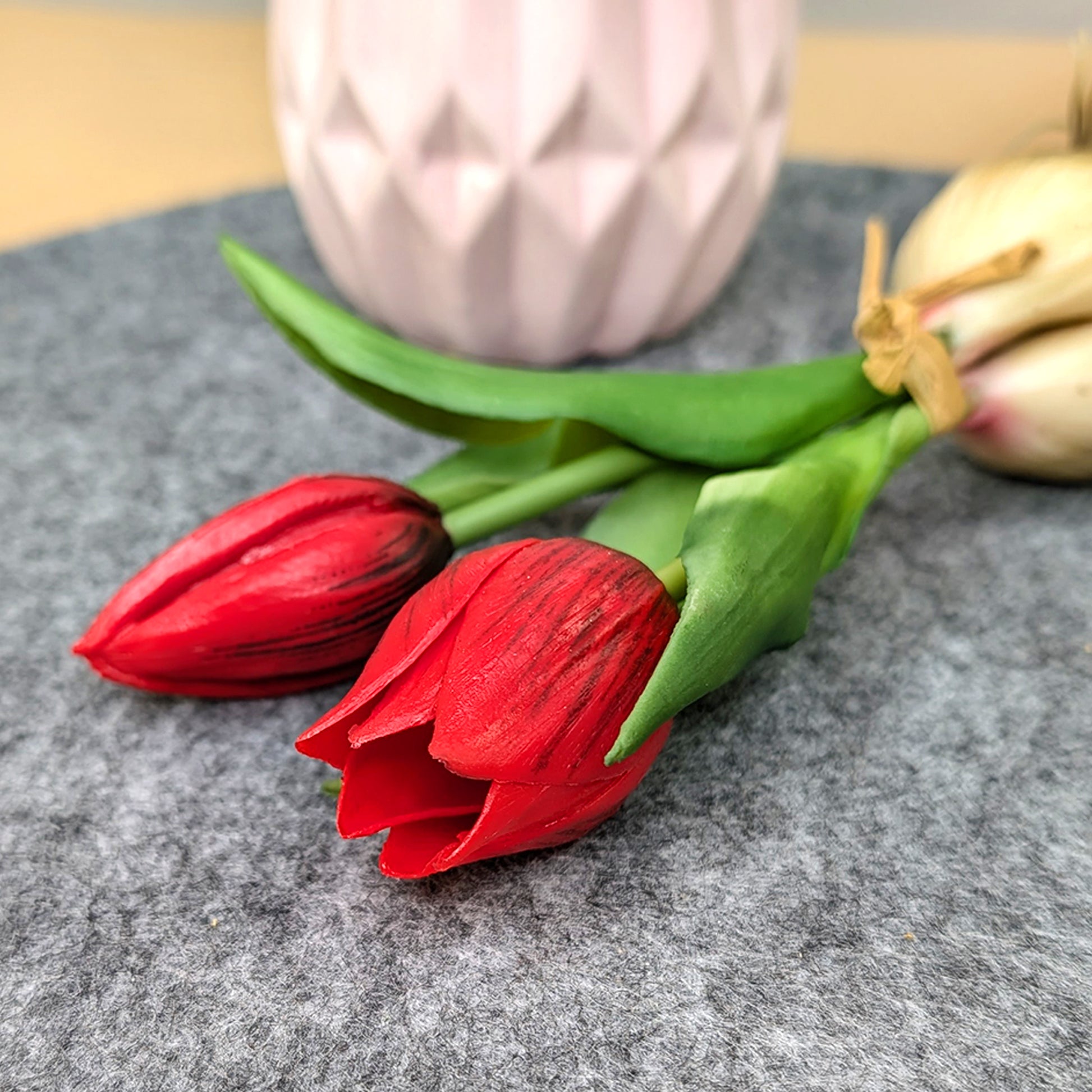 Nahaufnahme der roten Seidenblume mit grünen Blättern und weißer Zwiebel