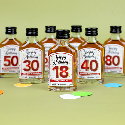 Miniatur-Kräuterlikörflasche „Happy Birthday 18“ vorne, dahinter weitere Flaschen mit Geburtstagszahlen 30, 40, 50, 70 und 80