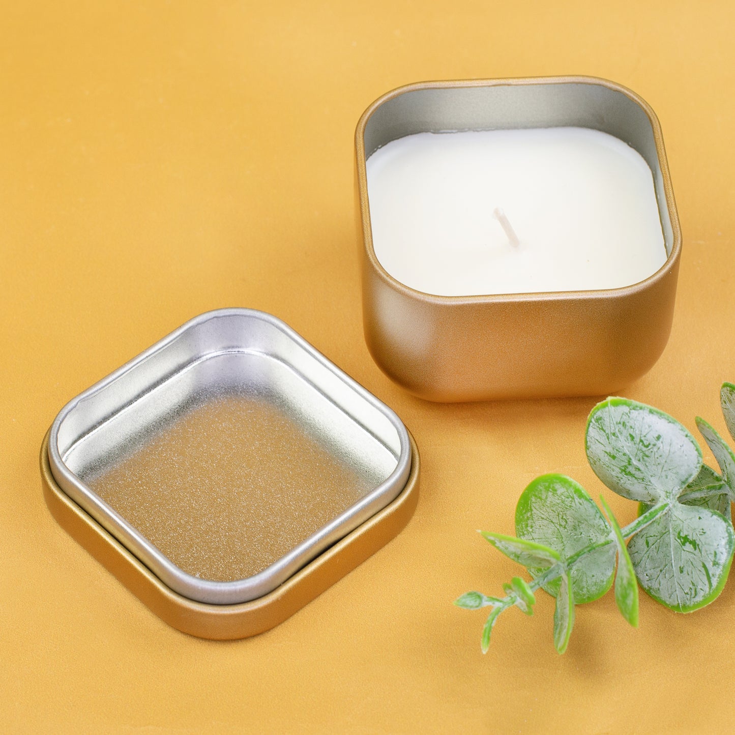 Geöffnete Mini Duftkerze in Gold zum Geburtstag mit Metalldeckel auf goldenem Hintergrund
