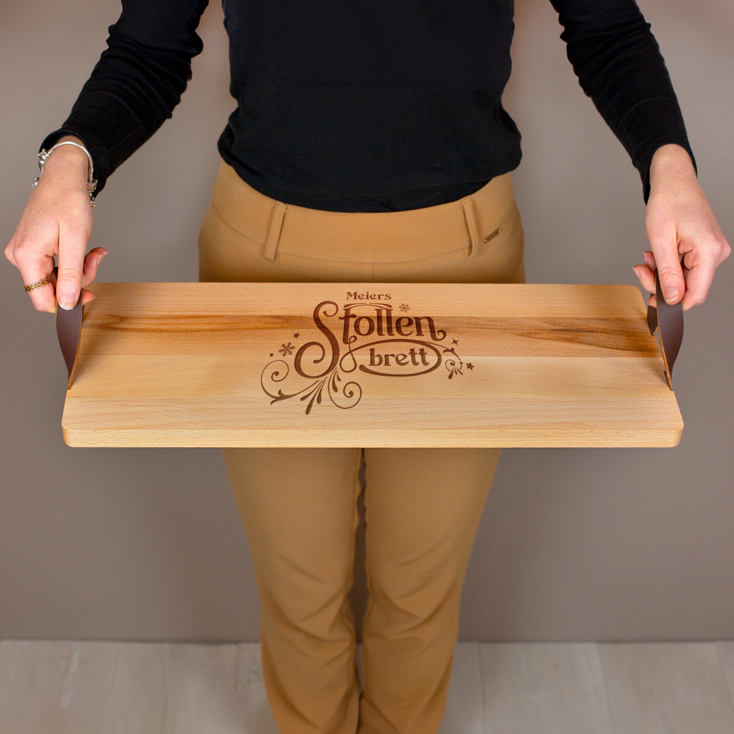 Holzbrett mit Gravur „Stollenbrett“ und personalisiertem Namen, getragen mit beiden Händen