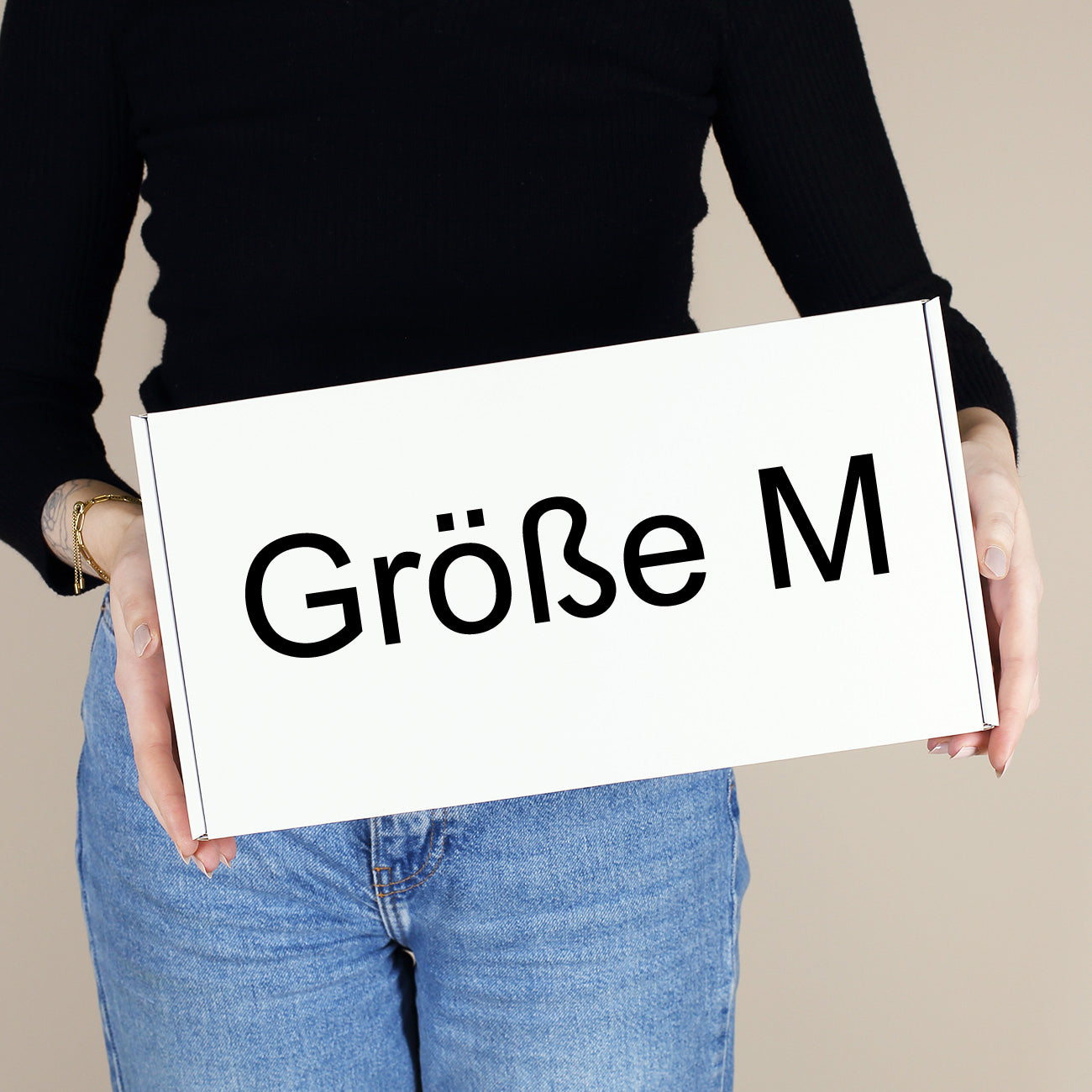 Weiße Geschenkbox Größe M quer in den Händen einer Person als Vergleichsbild für Geschenkboxen