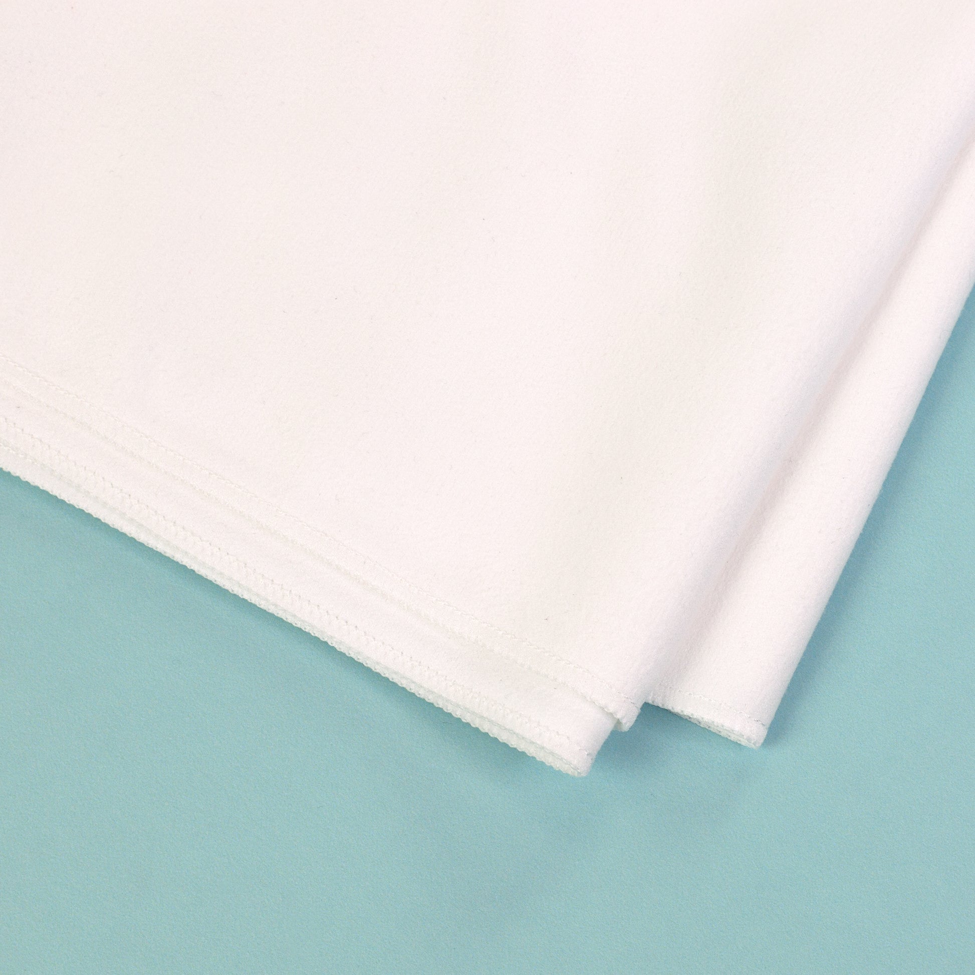 Detailaufnahme von Material und Naht eines weißen Sporthandtuchs