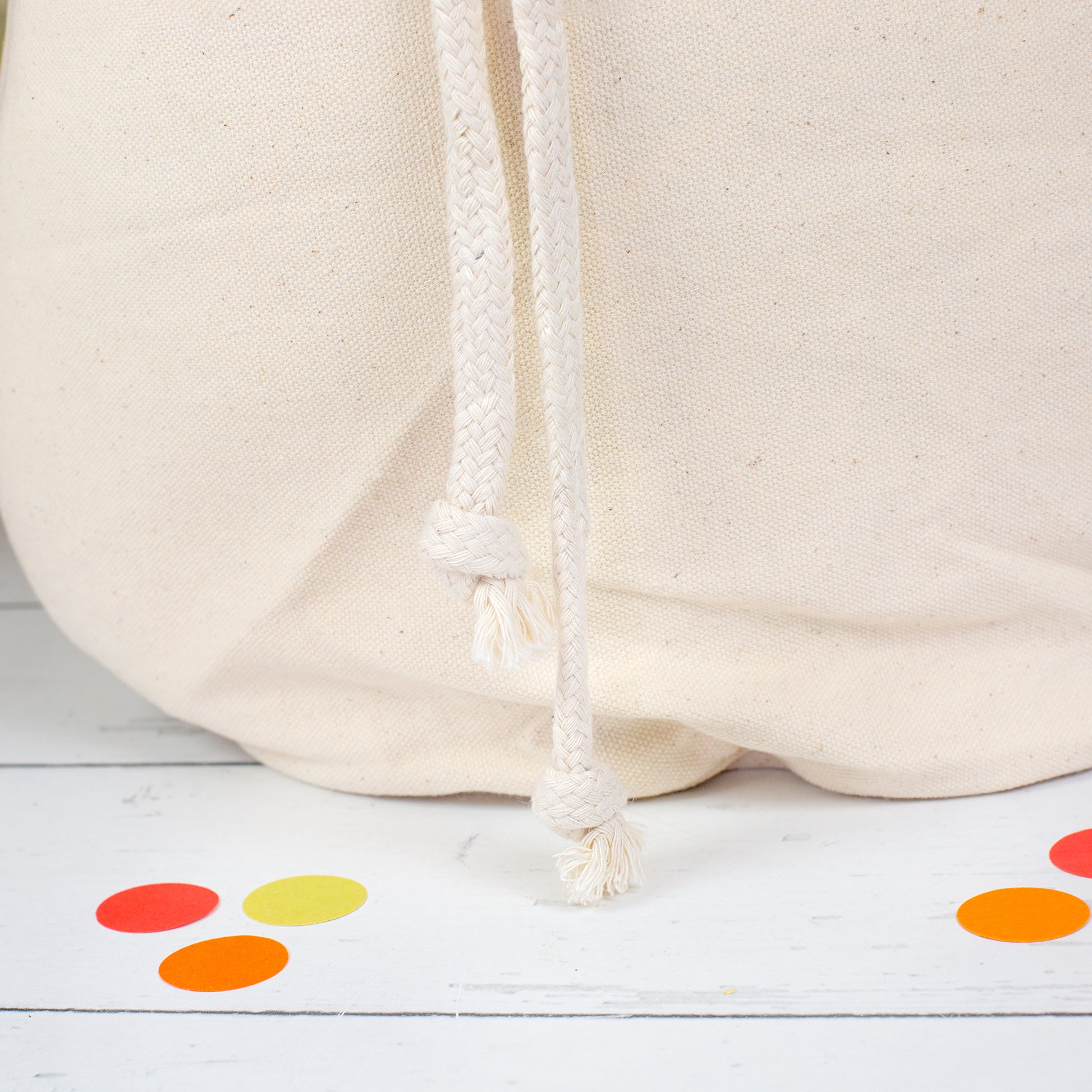 Detailbild des naturfarbenen Geschenksacks mit dicken Baumwoll-Kordeln und geknoteten Enden am unteren Rand
