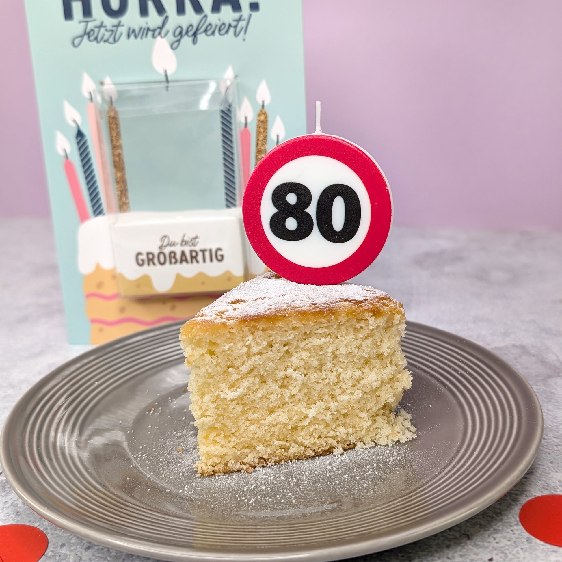 Nahaufnahme des Kuchen mit eingesteckter Verkehrszeichen-Kerze – Zahl 80 sichtbar