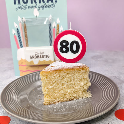 Nahaufnahme des Kuchen mit eingesteckter Verkehrszeichen-Kerze – Zahl 80 sichtbar