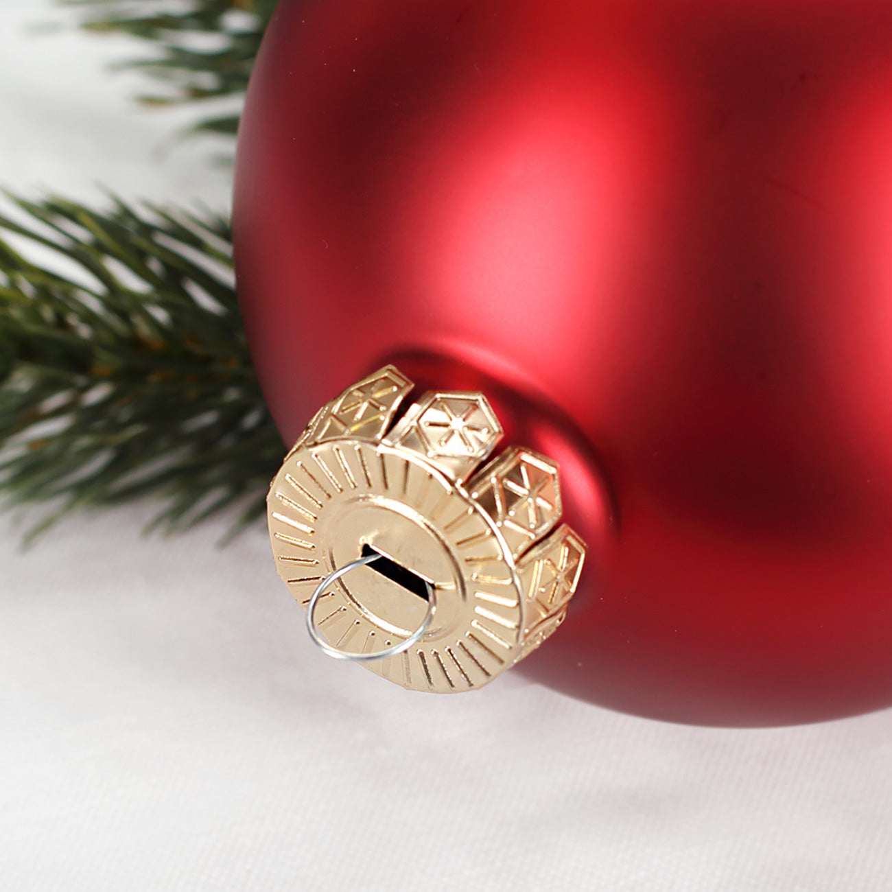 Detail goldene Aufhängung einer roten Weihnachtskugel