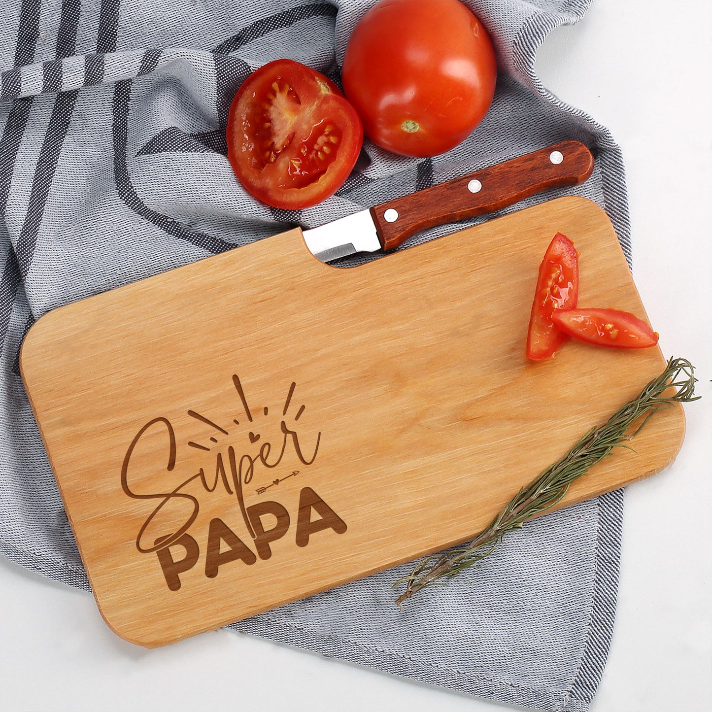 Schneidebrett aus Holz mit Messer und frischen Zutaten wie Tomaten