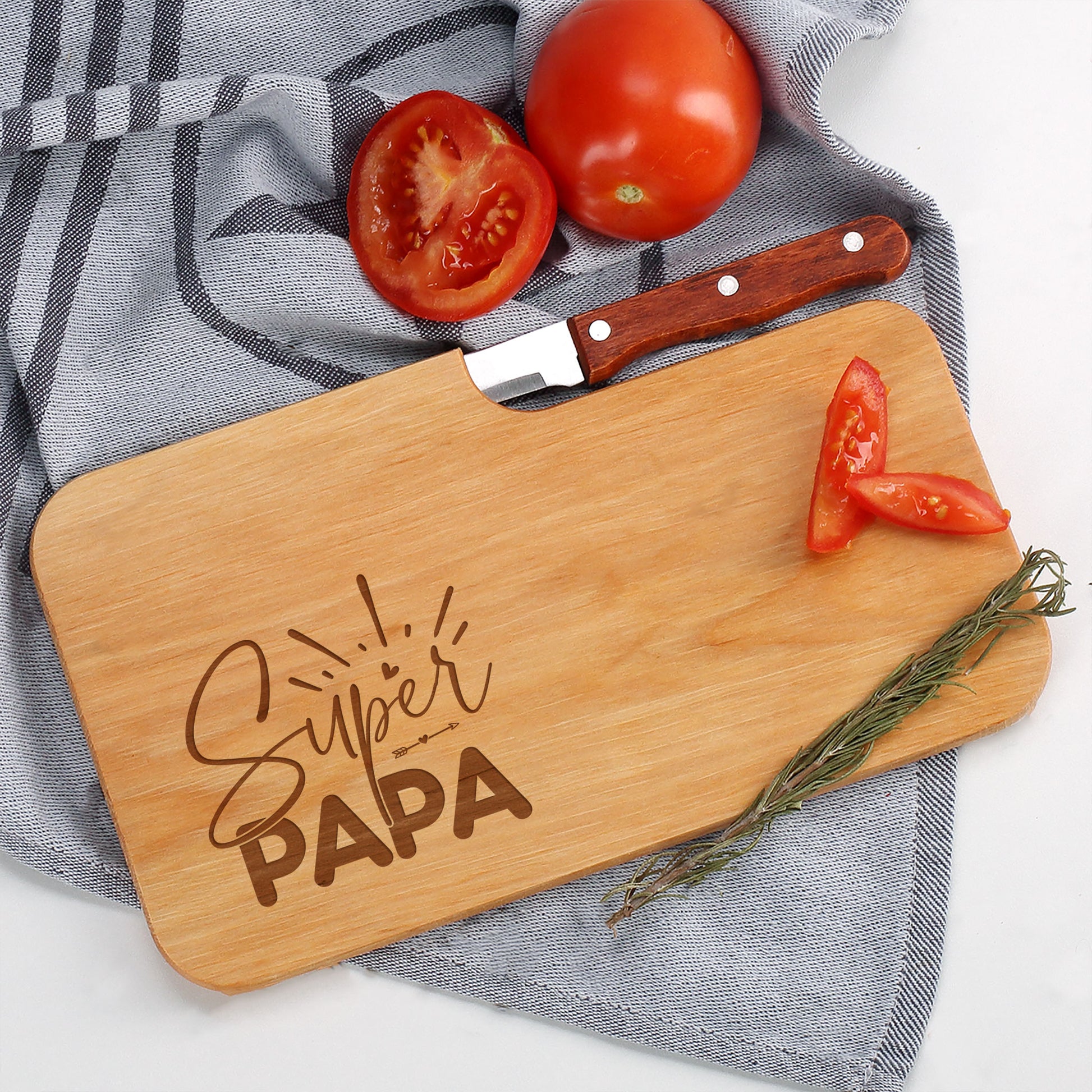 Schneidebrett aus Holz mit Messer und frischen Zutaten wie Tomaten