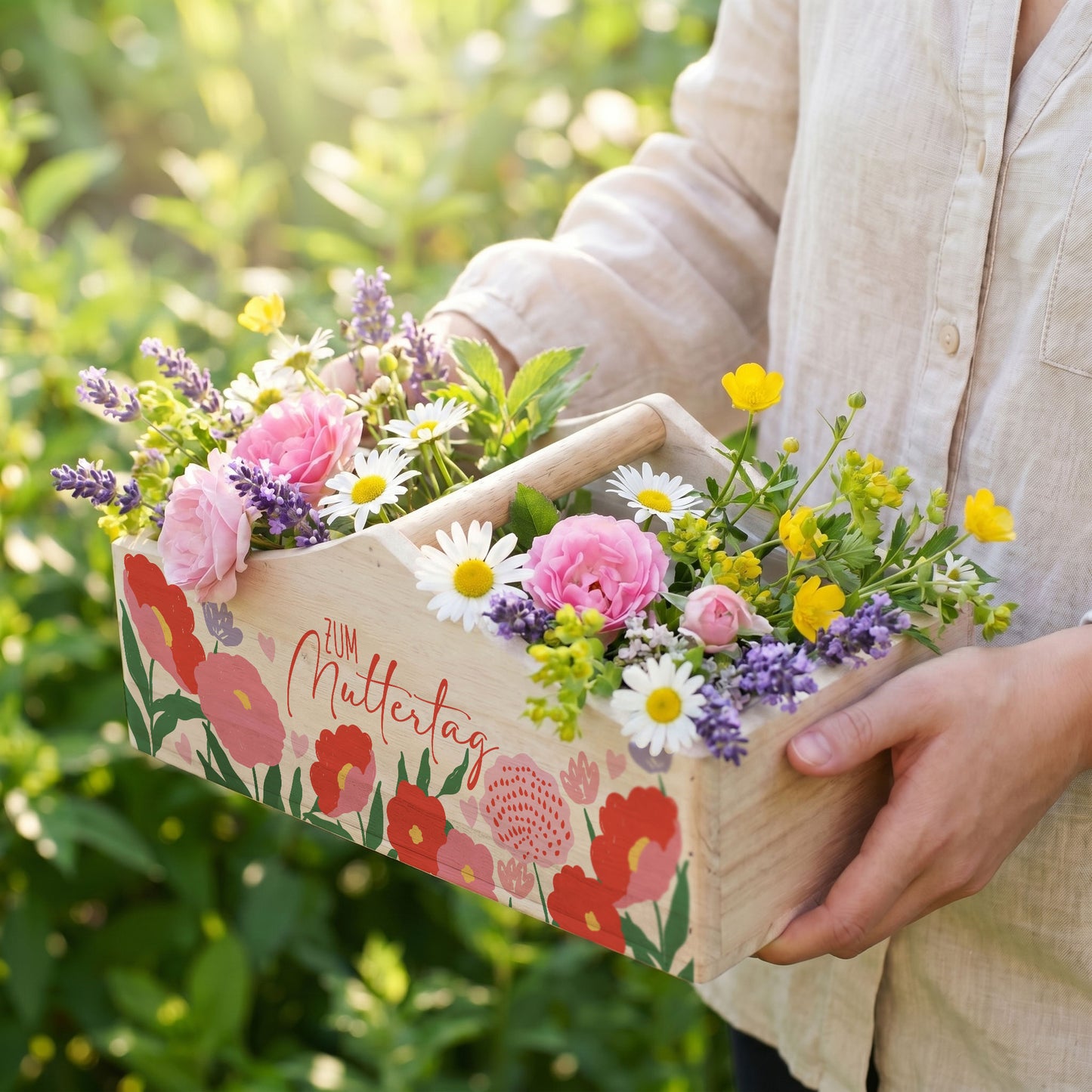 Pflanzkorb mit bunten Blumen im Garten als Geschenkverpackung zum Muttertag