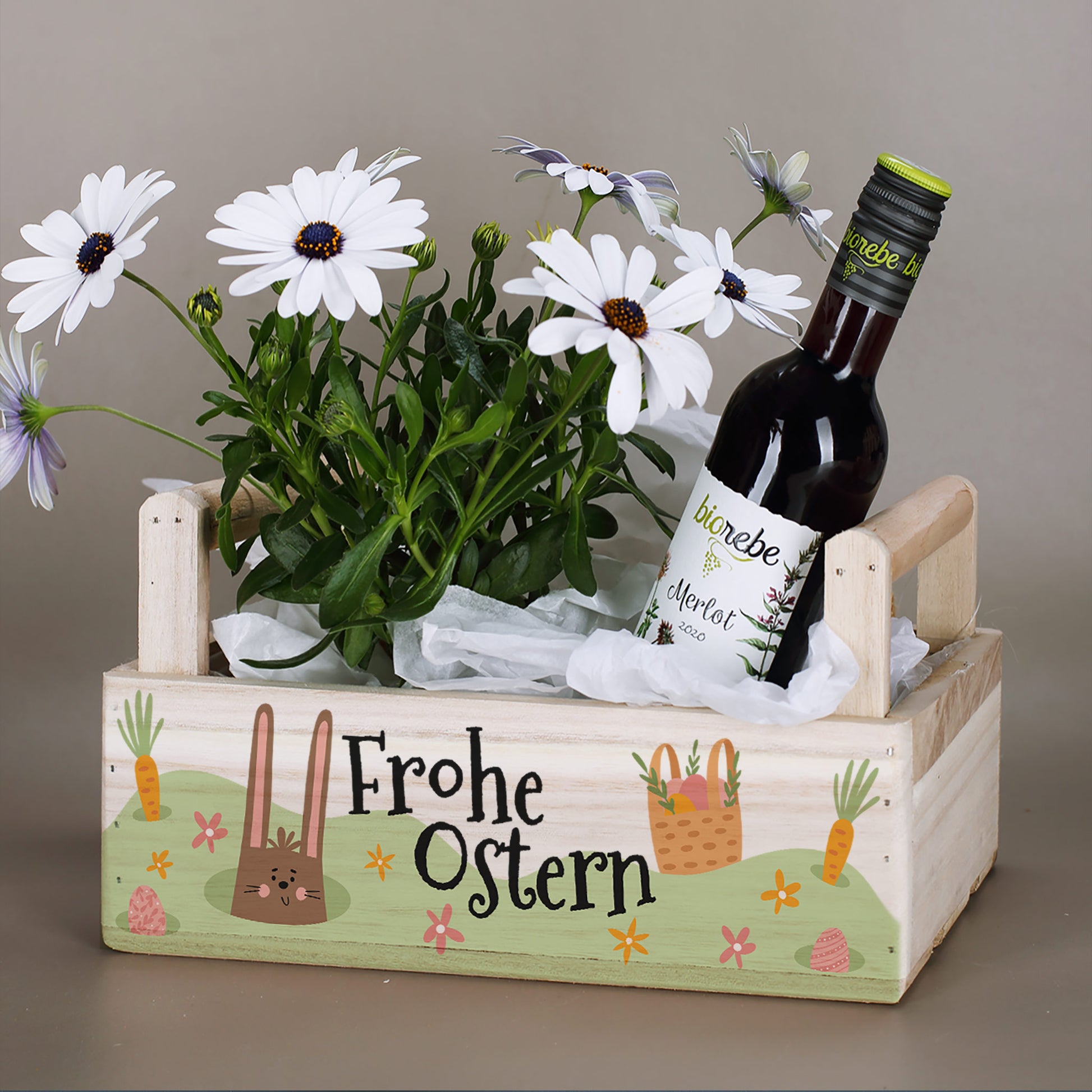 Holz Pflanzkorb mit zwei Griffen und Osterhasenmotiv „Frohe Ostern“ mit Blumen und Weinflasche dekoriert