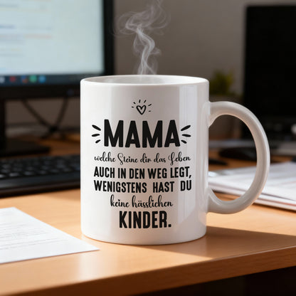 Mama-Tasse mit humorvollem Text auf einem Schreibtisch neben Laptop und Unterlagen, dampfend gefüllt