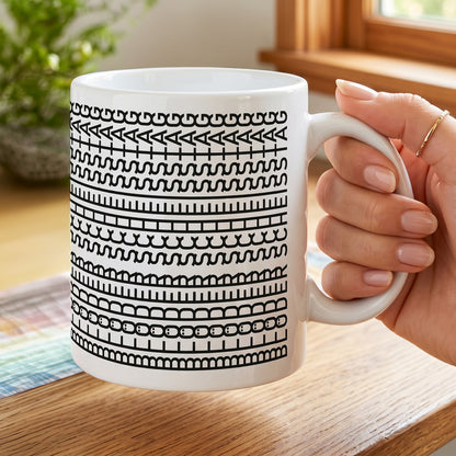 Tasse mit grafischem Schwarz-Weiß-Motiv und versteckter Botschaft „Blöder Scheißtag“ in einer Hand gehalten