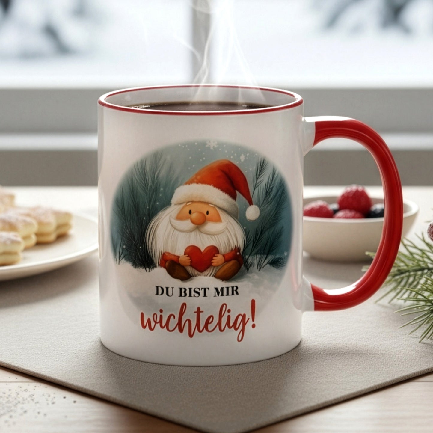 Dampfende Tasse mit Wichtel und Spruch „Du bist mir wichtelig!“ auf Tisch mit Gebäck und winterlicher Deko – Nahaufnahme.