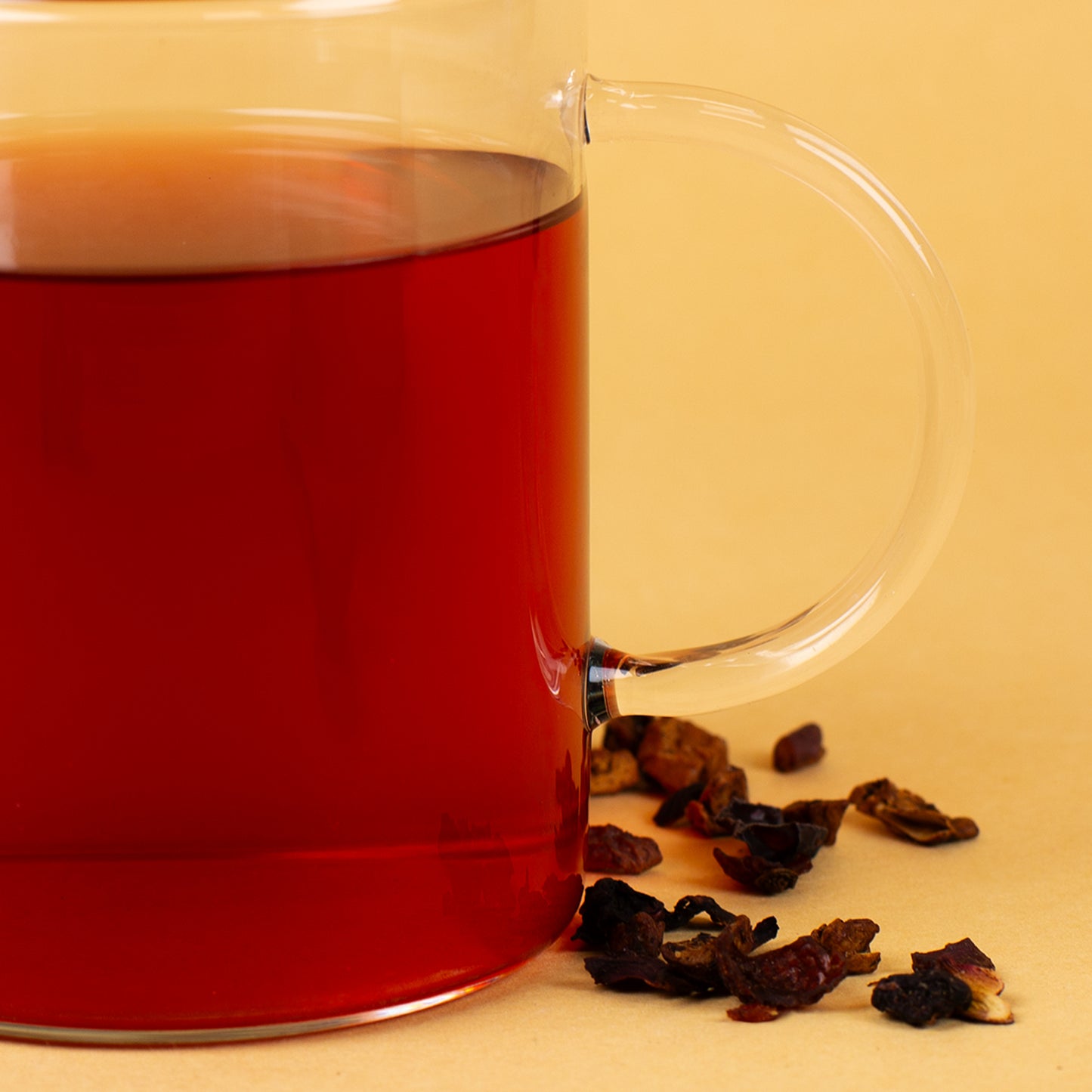 Detailaufnahme des Henkels und Glasrandes eines Leonardo-Teeglases mit Tee und dem Spruch „Einatmen, Ausatmen, Lächeln“.