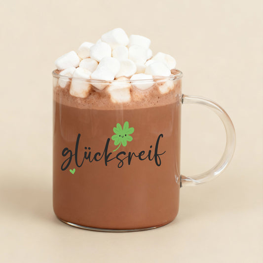 Teeglas mit „glücksreif“-Motiv gefüllt mit Kakao und Marshmallows
