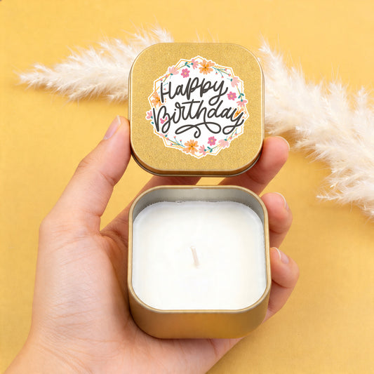 Hände halten goldene Mini Duftkerze mit geöffnetem Happy Birthday Deckel