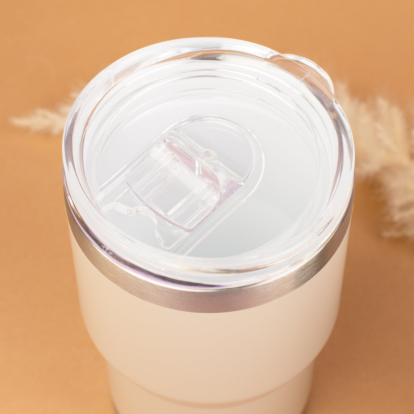 Draufsicht auf beigen Thermobecher mit transparentem Deckel und Trinköffnung