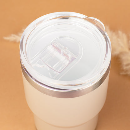 Draufsicht auf beigen Thermobecher mit transparentem Deckel und Trinköffnung