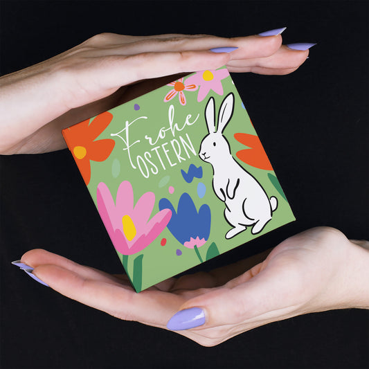 Kleine Oster Geschenkbox mit Schokolade wird in Händen gehalten