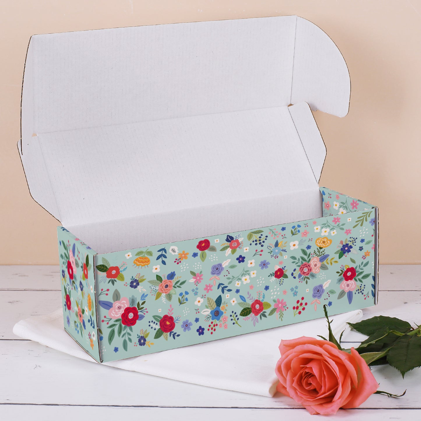Geöffnete längliche Geschenkbox mit Blumenmuster zum Muttertag, dekoriert mit Rosen – zeigt geräumiges Innenvolumen