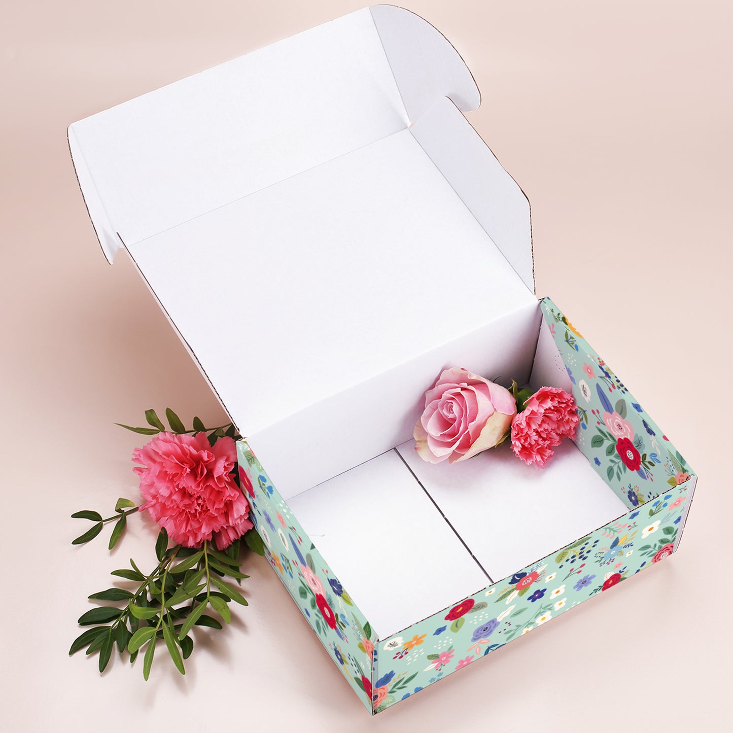 Geöffnete große Muttertags-Geschenkbox mit Blumenmuster, leer, dekoriert mit Rosen und Nelken