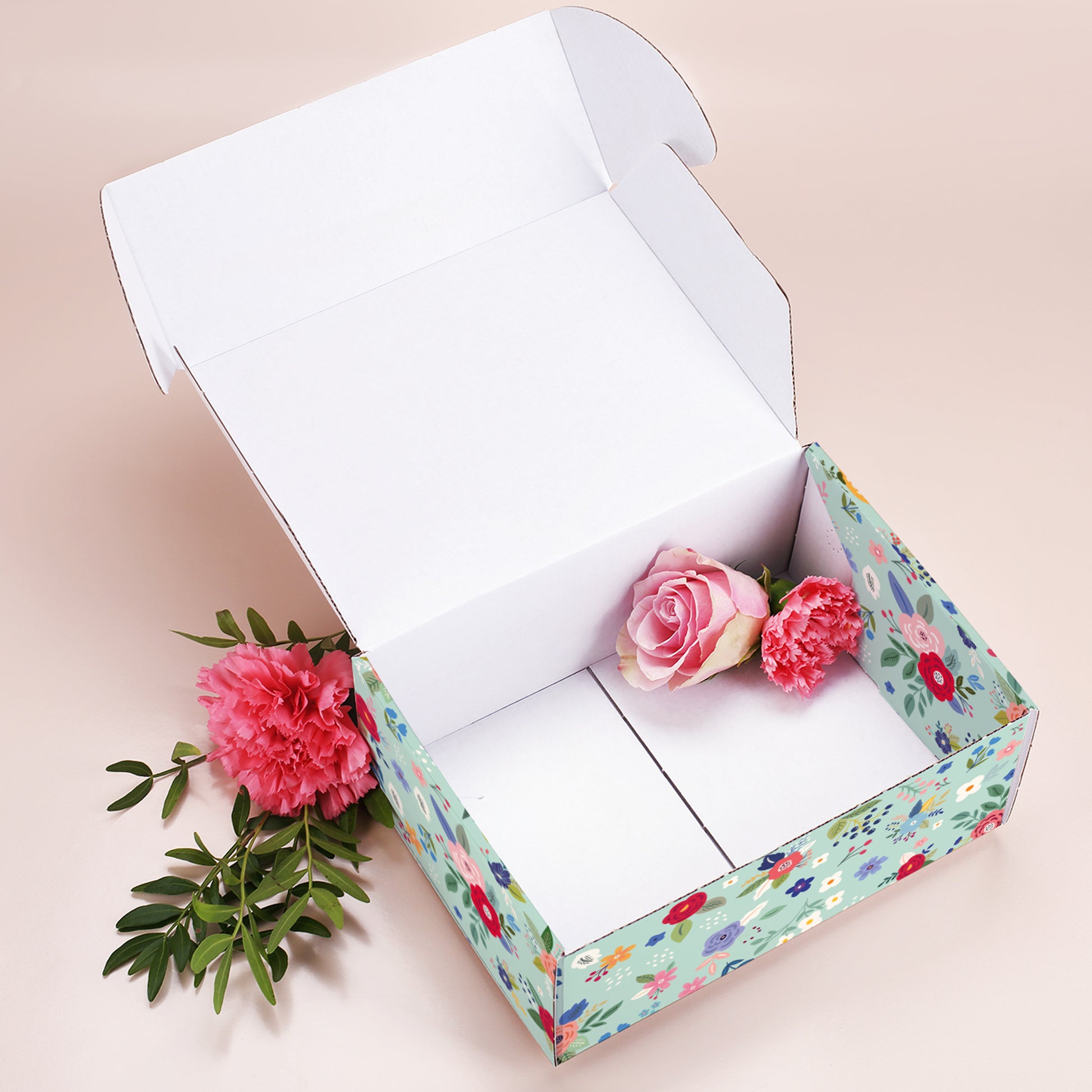 Geöffnete große Muttertags-Geschenkbox mit Blumenmuster, leer, dekoriert mit Rosen und Nelken