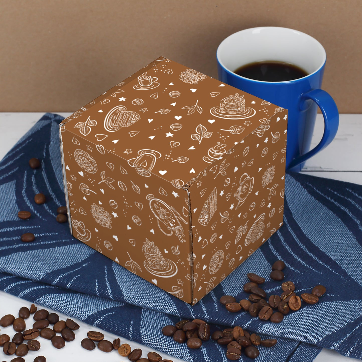 Braune Geschenkbox mit Kaffeebohnen- und Tassenmotiv, leicht von oben und schräg fotografiert.