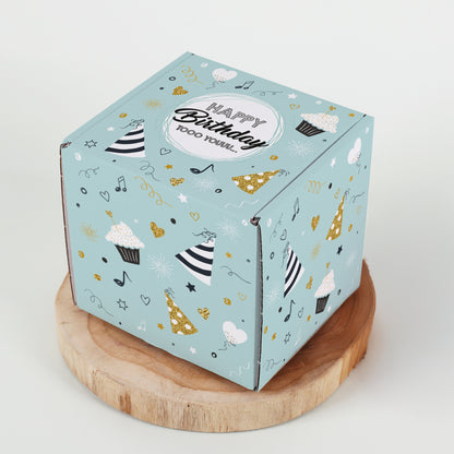 Quadratische Geburtstagsbox auf Holzplatte mit rundum bedrucktem Partymotiv