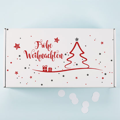 Weiße Geschenkbox von oben mit rotem Weihnachtsbaum Motiv, Geschenken, Sternen und Frohe Weihnachten Schriftzug