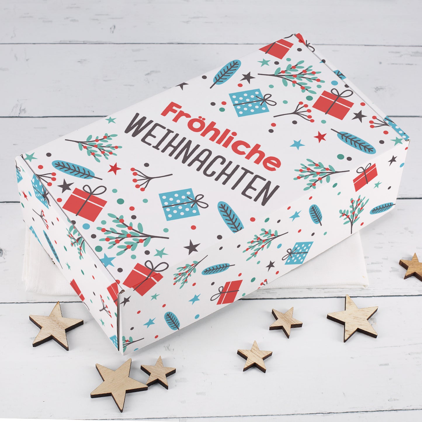 Weiße Geschenkbox zu Weihnachten mit Fröhliche Weihnachten Schriftzug, Geschenk Motiven, Zweigen, Sternen und Holzsternen als Dekoration