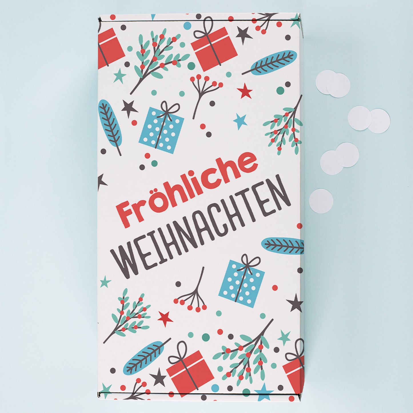Weihnachts Geschenkbox von oben mit buntem Geschenkpapier Motiv, Zweigen, Sternen und großem Fröhliche Weihnachten Schriftzug