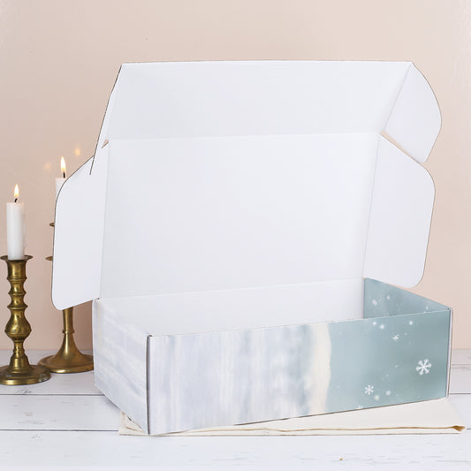 Geöffnete Geschenkbox mit winterlichem Druck, leer und von innen weiß