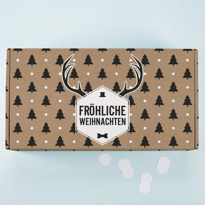 Kraftpapier Geschenkbox von oben mit Tannenbaum Muster, weißen Punkten, Rentier Motiv und Fröhliche Weihnachten Schriftzug