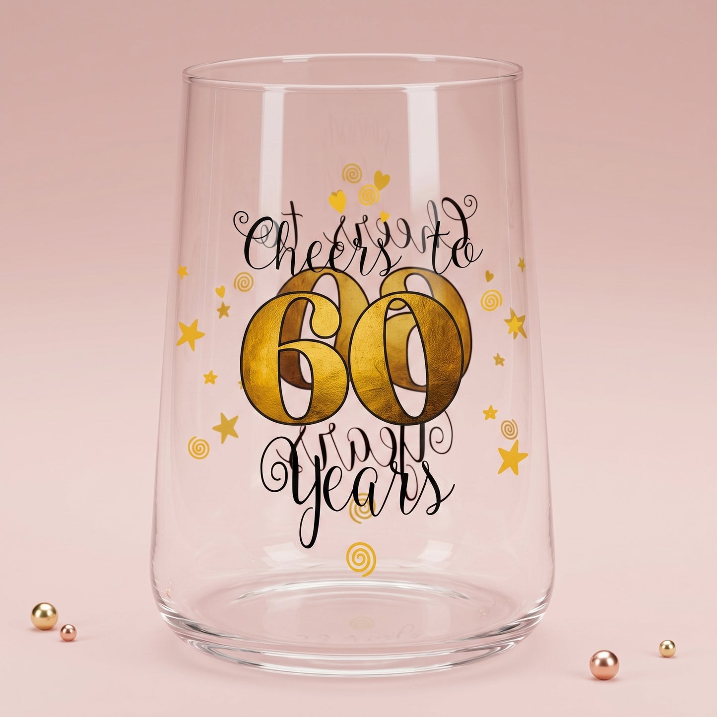 Leeres Trinkglas mit Cheers to 60 Years Aufdruck auf rosa Hintergrund