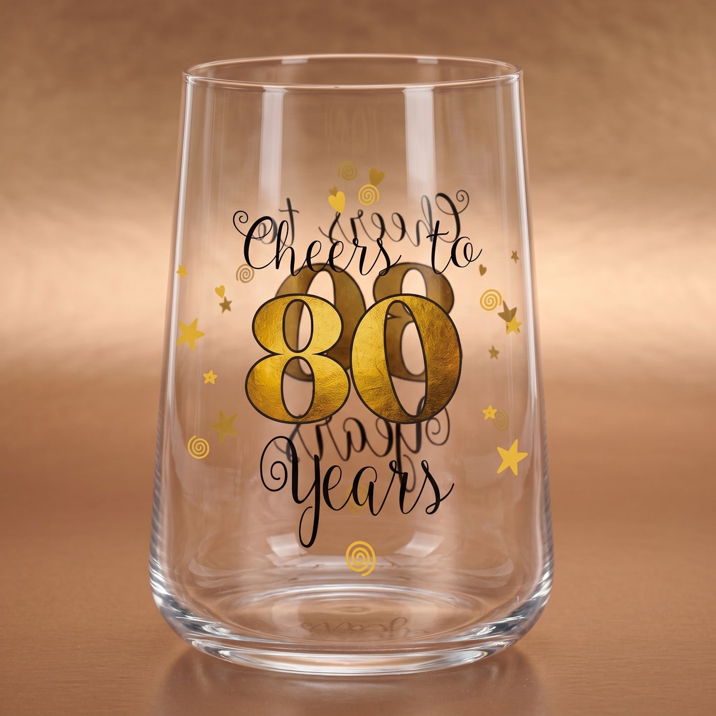 Leeres Trinkglas zum 80. Geburtstag mit goldener 80 und dekorativen Sternen auf warmem Holzuntergrund