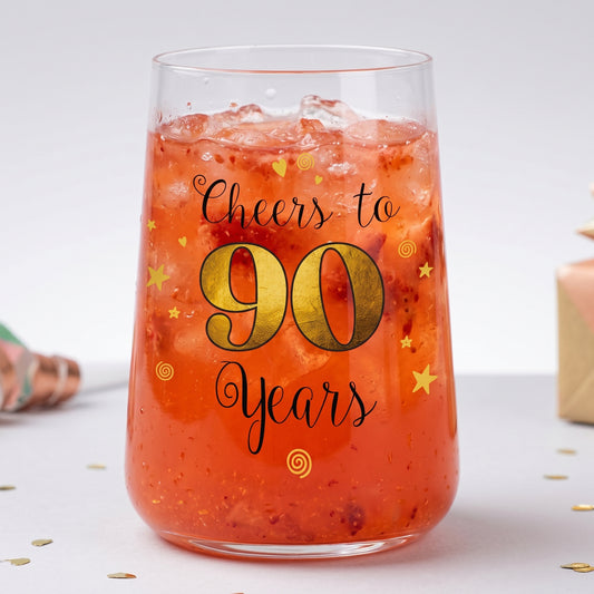 Cocktailglas zum 90. Geburtstag mit rotem Getränk, Eiswürfeln und festlichem Aufdruck