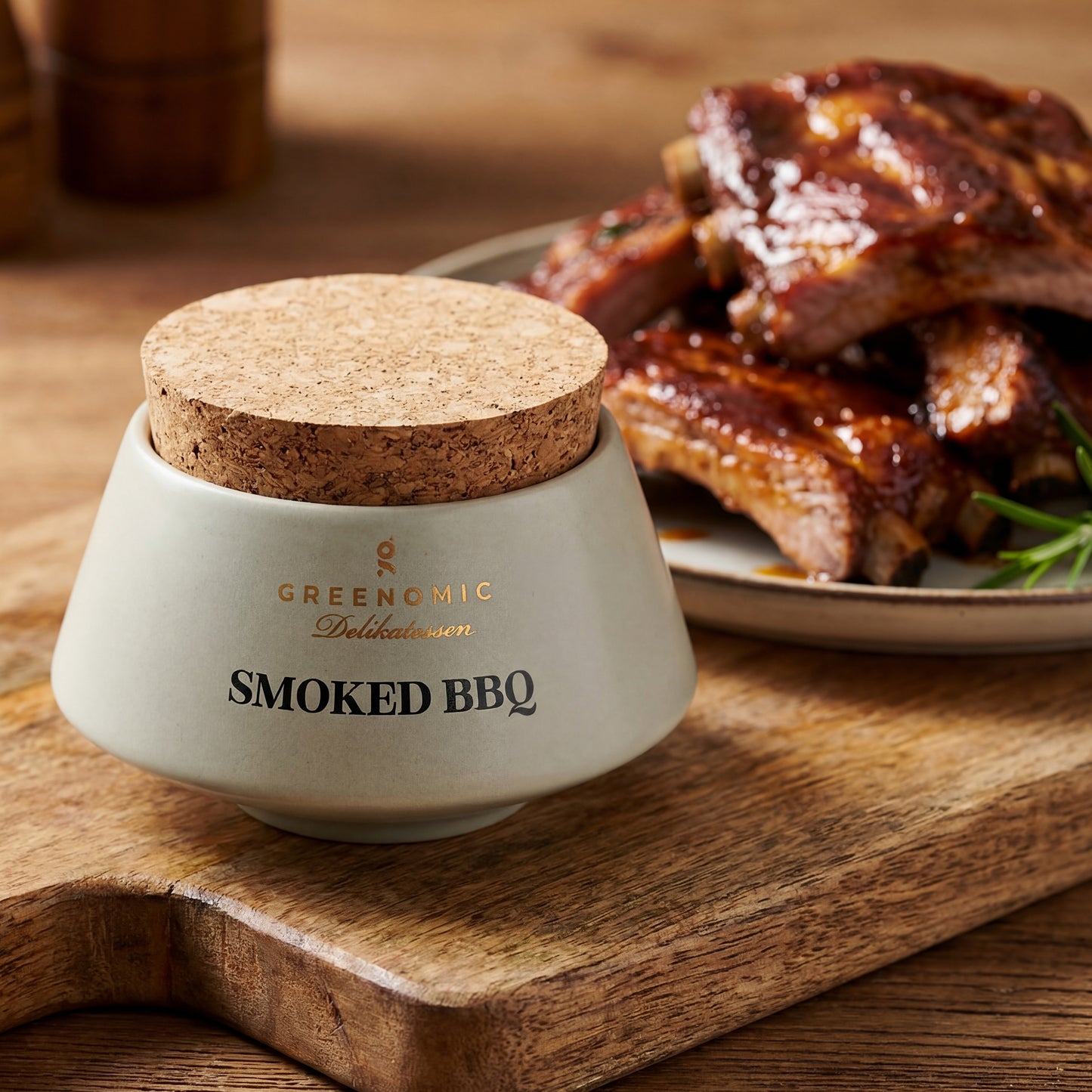 Smoked BBQ Gewürz neben saftigen BBQ-Rippchen auf Holzbrett angerichtet