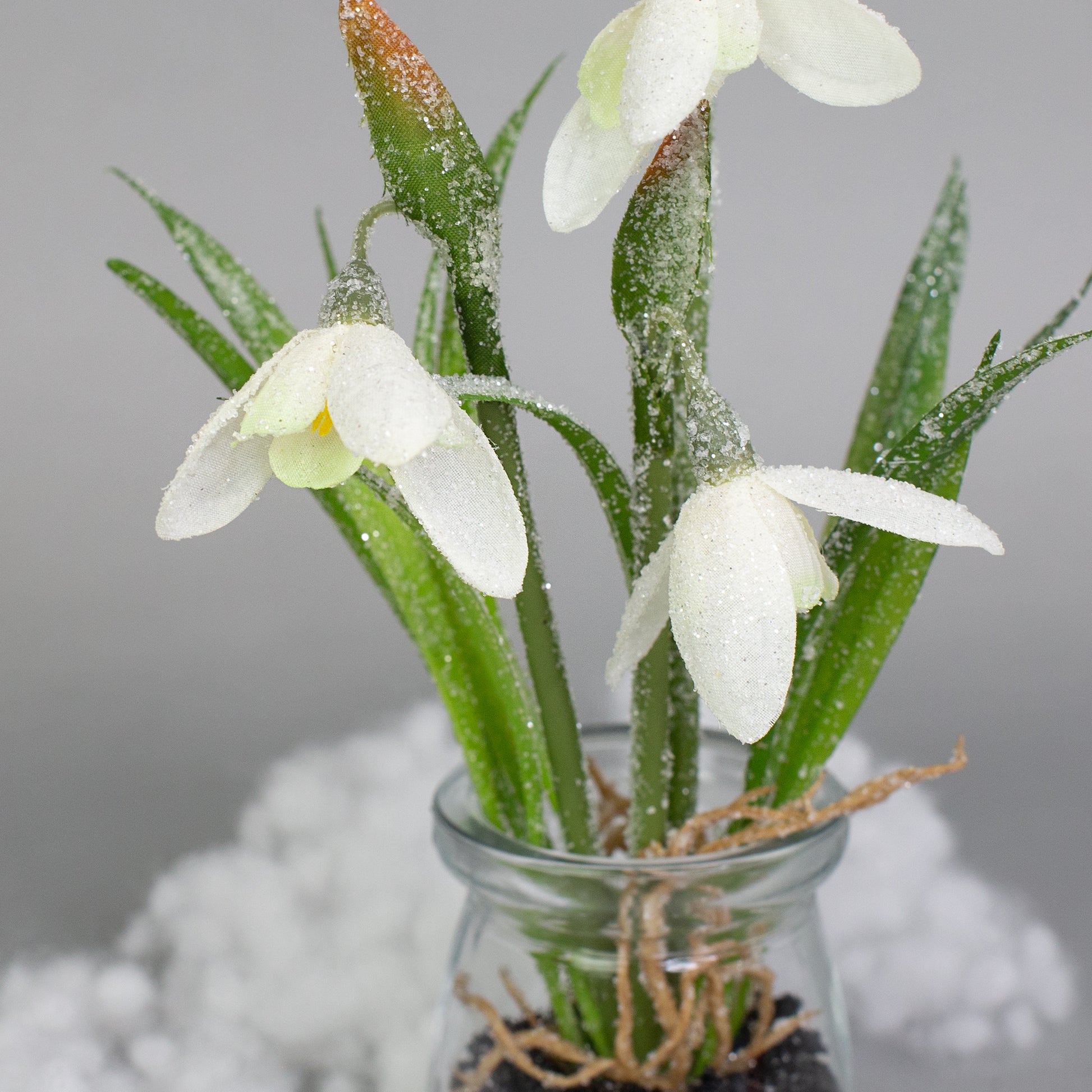 Nahaufnahme der glitzernden Blüten mit Frostoptik – Kunstpflanze Schneeglöckchen