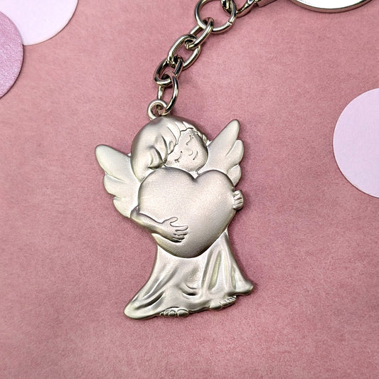 Schutzengel-Schlüsselanhänger aus Metall mit umarmtem Herz – frontal fotografiert
