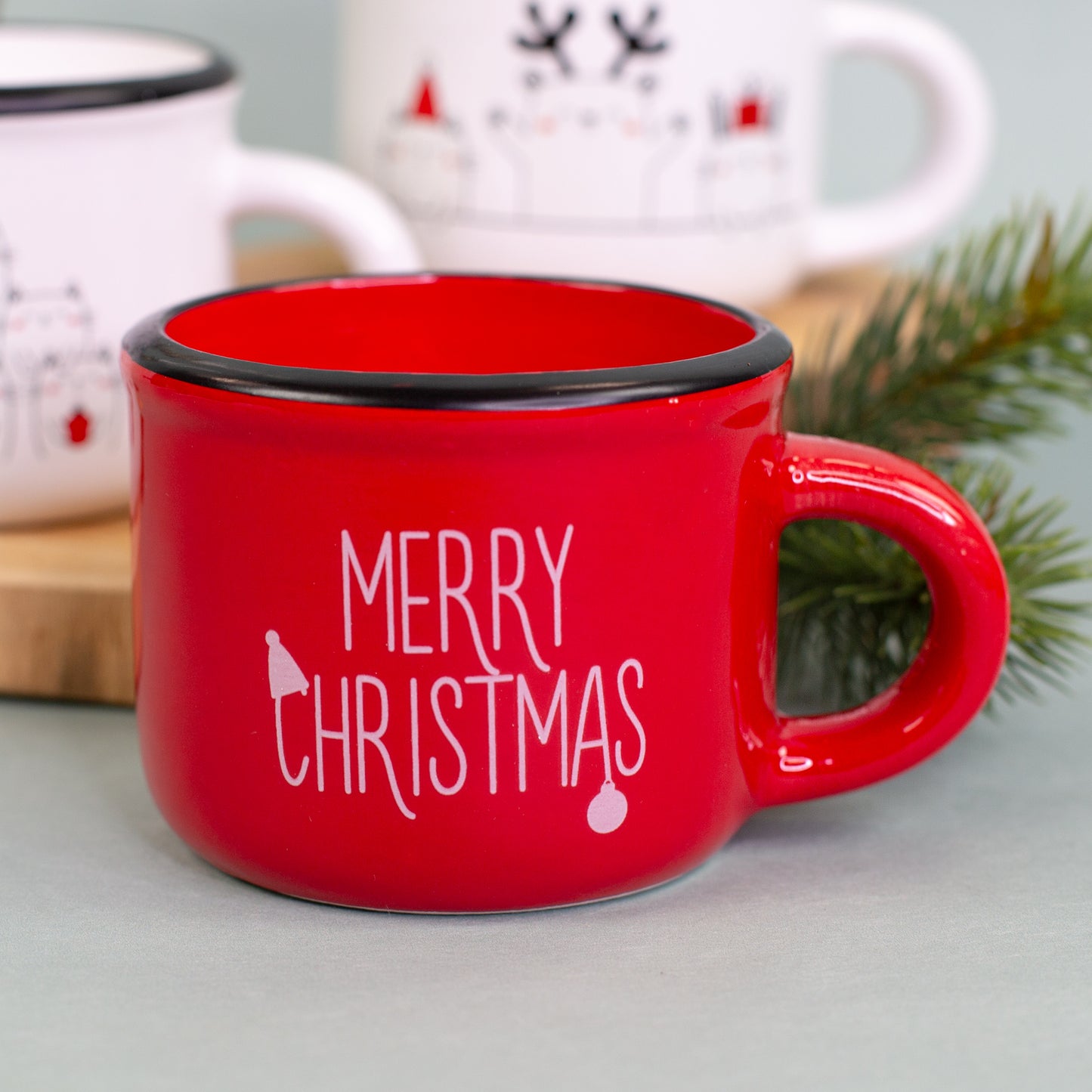 Rote Dolomitetasse mit weißem Merry-Christmas-Schriftzug als Kerze